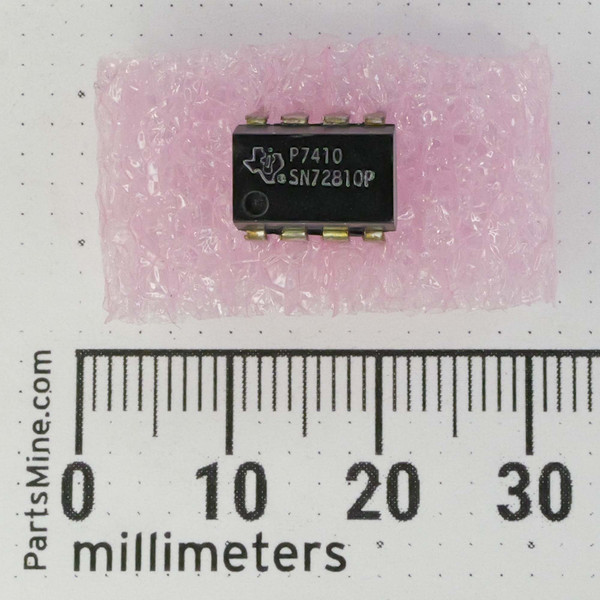 Texas Instruments SN72810P differential comparator integrated circuit in a black plastic DIP-14 package, marked with the TI logo and date code P7410, resting on pink anti-static bubble wrap next to a millimeter scale ruler.