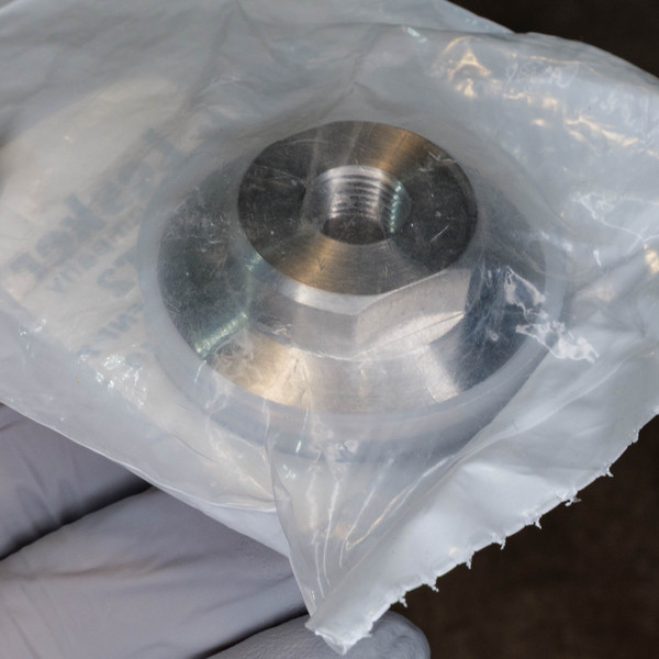 Stainless steel vacuum adapter showing clean, sharp threads, no visible corrosion or damage. Still in original clear plastic bag.