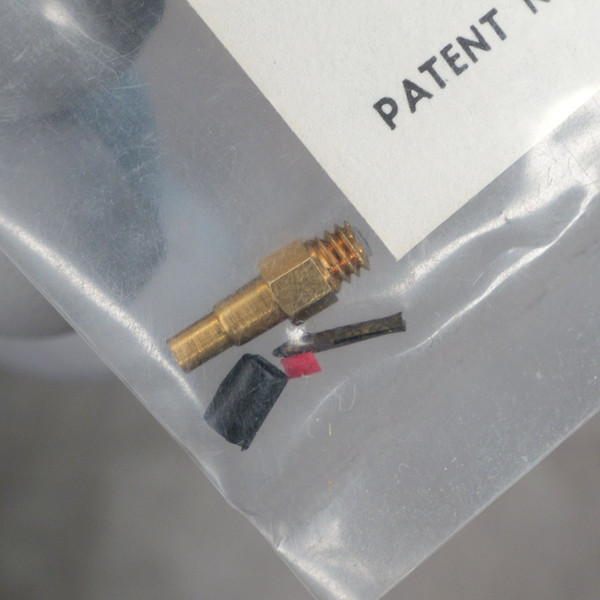 Gold-plated connector with hex fitting and barbed stem; two short leads with black and red insulation visible, no visible damage.