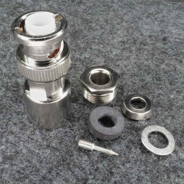 Nickel-plated body with knurled coupling ring, white dielectric visible at face. All hardware pieces present: hex nut, lock washer, flat washer, rubber grommet, and center pin.
