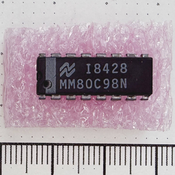 Top view of National Semiconductor MM80C98N 16-pin DIP IC on pink foam.