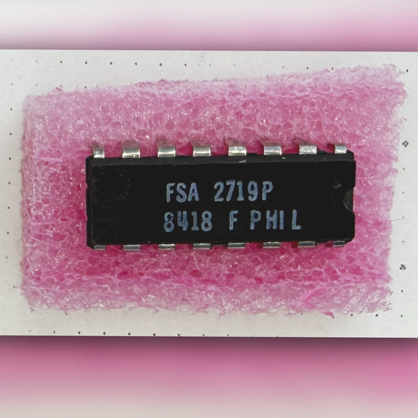 Top view of a Fairchild FSA2719P DIP-16 integrated circuit seated in pink foam.