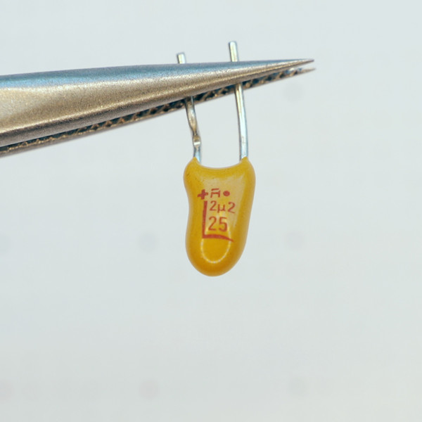 Front view of yellow dipped tantalum capacitor showing 2μ2 25V markings.
