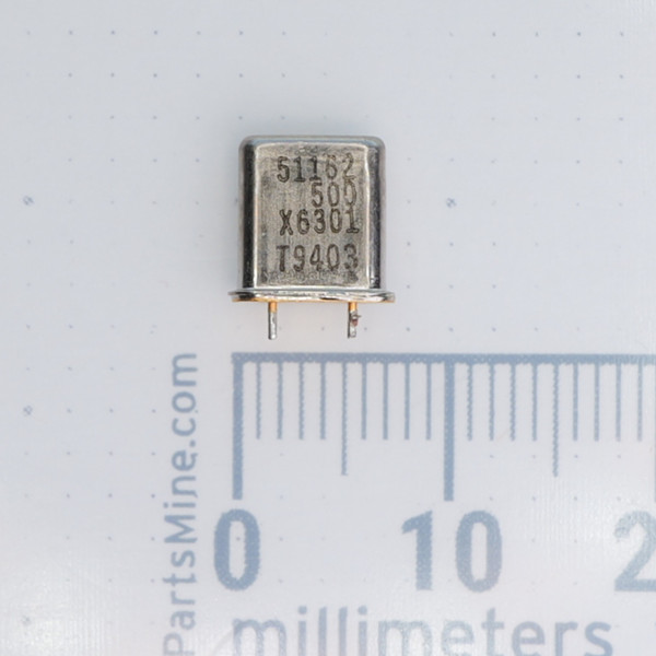 Front view of metal can crystal marked 51162 500 X6301 T9403 against a millimeter ruler.