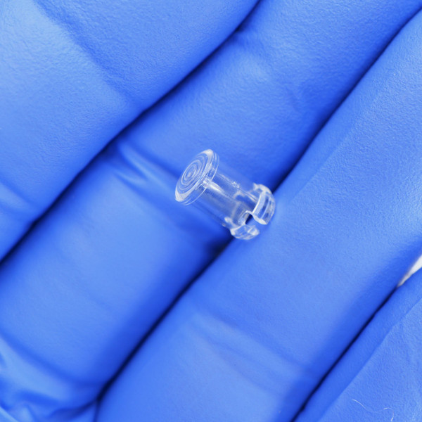 Side profile of a PartsMine A-4302 clear plastic LED clip on gloved fingers.
