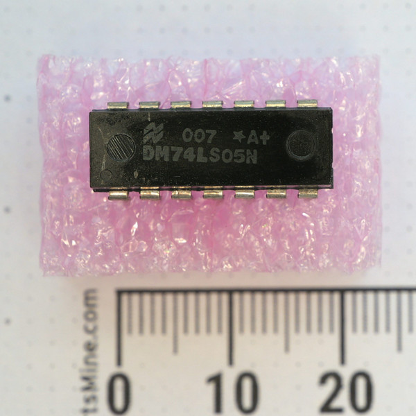 Top view of a National Semiconductor DM74LS05N DIP IC on protective foam next to a metric ruler.