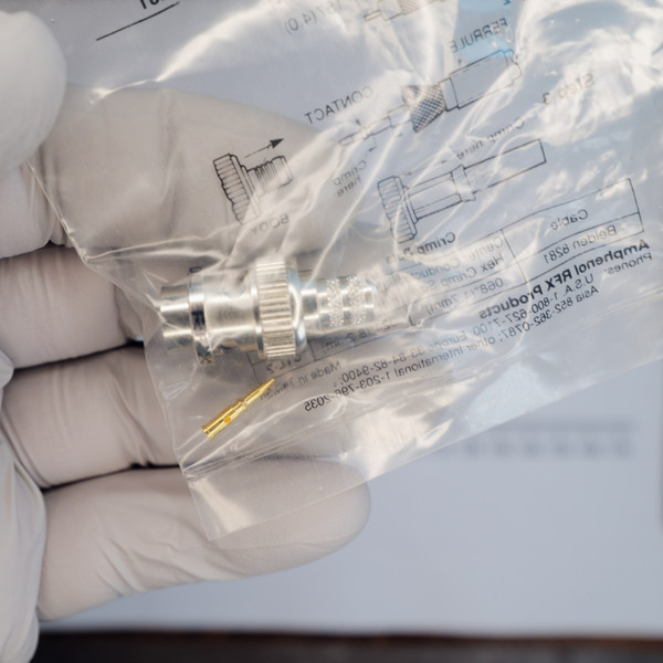 Amphenol RFX 31-321-10RFX BNC plug and contact pin inside plastic packaging.