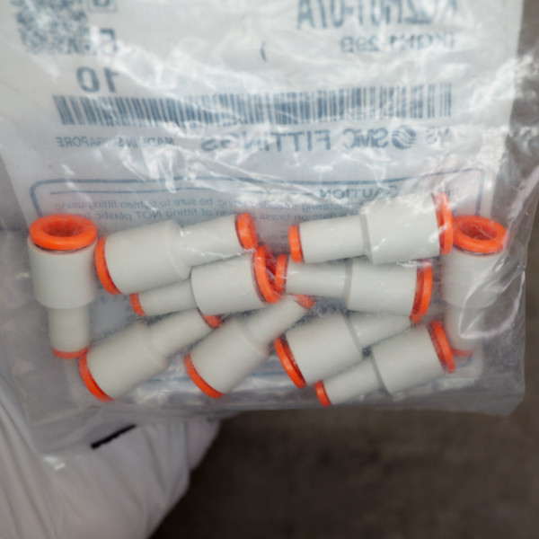 Close-up view of SMC KQ2H01-07A push-in pneumatic tube fittings inside plastic bag.