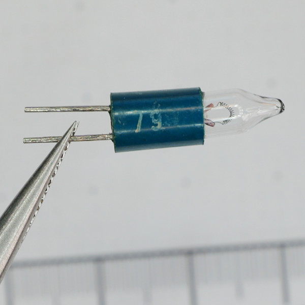 Close-up of Unbranded CM9 7997 miniature light bulb held in tweezers.