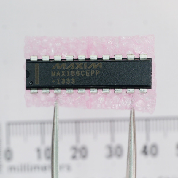 Top view of Maxim MAX186CEPP integrated circuit on foam next to a ruler.