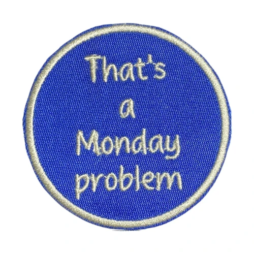 It’s a round embroidered patch with a soft, light‑colored border and a deep blue background. Centered on the patch, stitched in pale thread, is the playful phrase “That’s a Monday problem.” The clean lettering and simple color palette give it a crisp, modern look, while the message adds a humorous, laid‑back vibe—perfect for anyone who enjoys a little tongue‑in‑cheek procrastination.