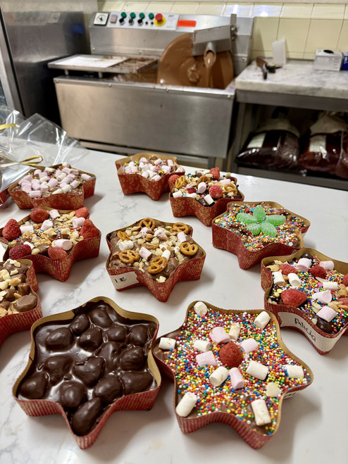 Finished handmade rocky road created during The Treat Factory's DIY Rocky Road Experience in Berry NSW, displayed on a table with the chocolate flavour wheel in the background.