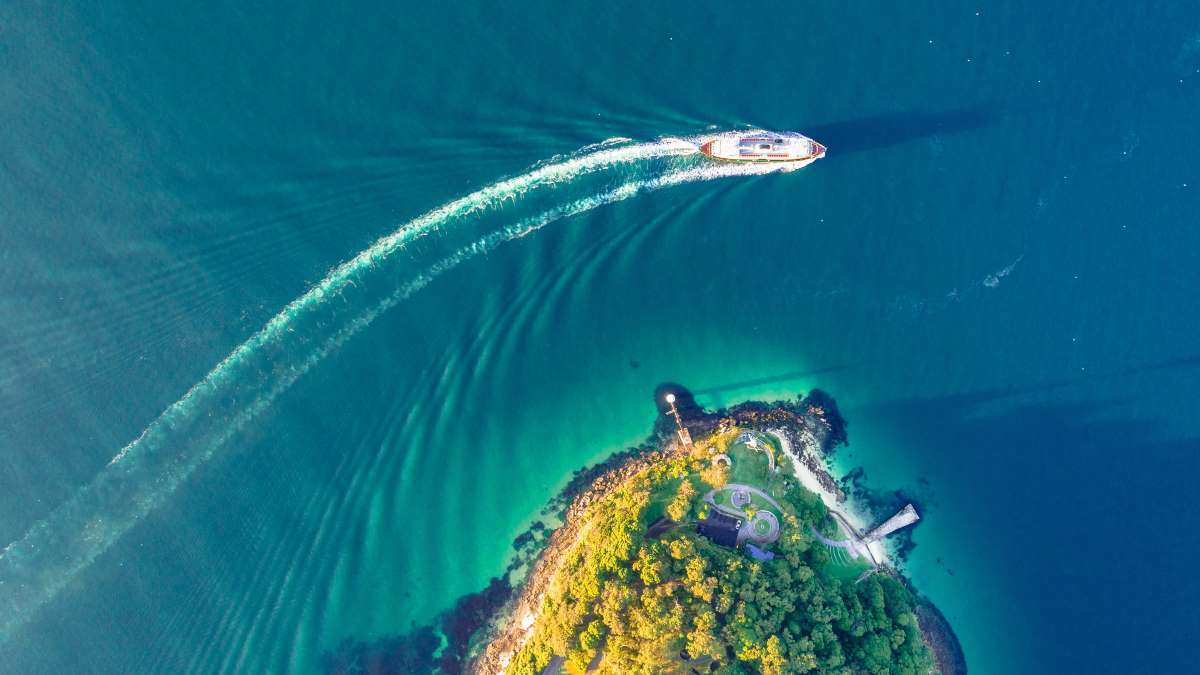 A bird's eye view of a water taxi  moving across the ocean waves.