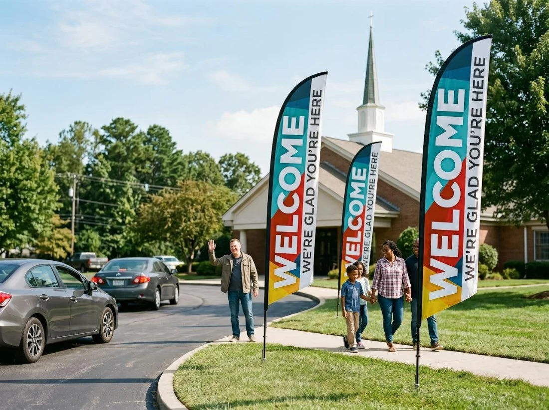 Welcome feather flags at a church entrance along a busy road