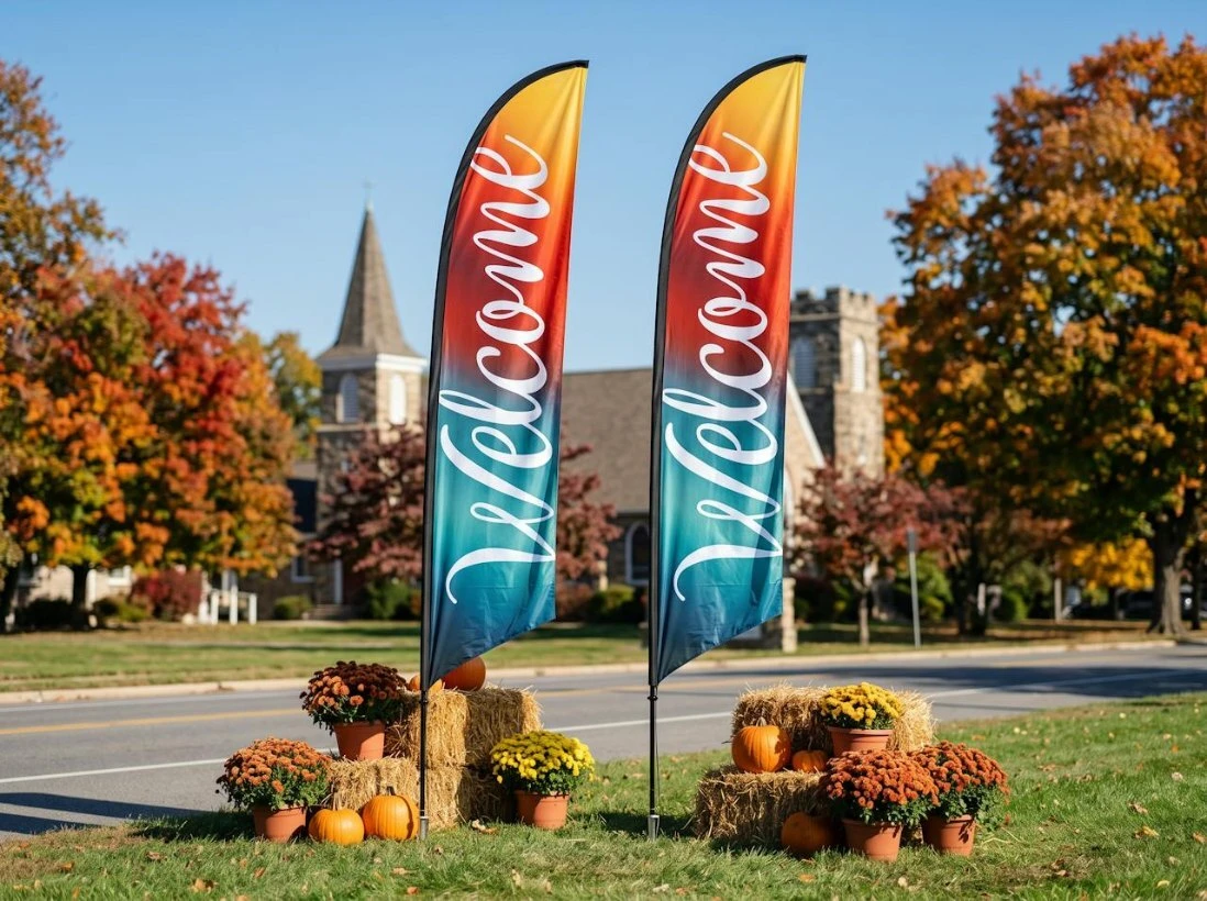 Fall feather flags with pumpkins and mums outside a church