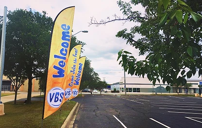 VBS feather flags in a church parking lot