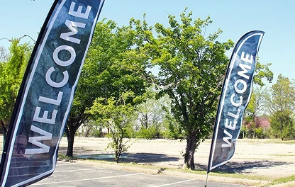 Welcome feather flags on a tree-lined church lawn