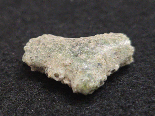 1.53 gram Trinitite specimen displayed under indoor light