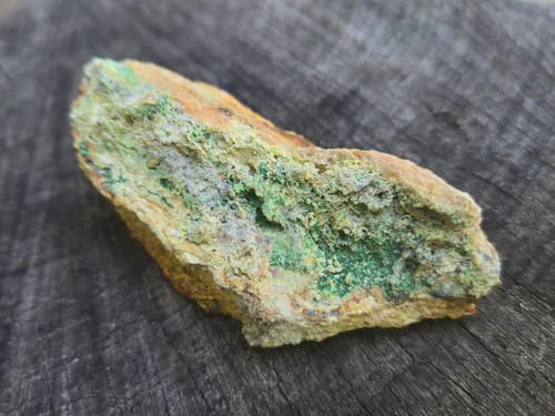 yellow/brown Parsonsite, tan Kasolite & green Metazeunerite on matrix displayed under outdoor light