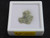 showing how this 1.1 Gram Trinitite sample with black inclusions is displayed under indoor light in a labeled case top view
