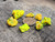7 Piece Autunite Lot under outdoor light demonstrating daytime fluorescence size comparison to copper penny
