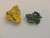 green Torbernite & yellow Parsonsite thumbnail sized specimens on display under indoor light