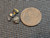 4 piece black uraninite specimens under indoor light size comparison to copper penny bottom view