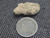 vitreous looking trinitite under indoor light size comparison to copper penny top view