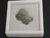 vitreous trinitite in white square labeled display case