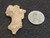 This vitreous looking trinitite specimen size comparison to steel penny top view