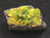 yellow/green autunite on black quartz matrix under indoor light