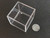 Clear acrylic display case on display under indoor light size comparison to steel penny top view
