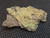 drab yellow/brown Andersonite with Schröckingerite on sandstone matrix under indoor light