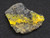 The larger specimen under indoor and 365nm light showing yellow orange globules of Bayleyite