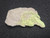 drab yellow Andersonite  on grainy Sandstone under indoor light