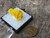 bright yellow 5 gram lamellar autunite formation on display under outdoor light