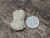 vitreous greyish green trinitite sample under outdoor light size comparison to steel penny top view