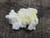 yellow boltwoodite on white gypsum matrix under outdoor light rotated