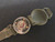 Olive drab Model 1949 Military Wrist Compass with open cover showing compass rotated