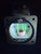 Type A-1 Oxygen Flow Indicator under 365NM UV light illumination showing weak yellowish green fluorescence