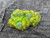 bright green and yellow lamellar autunite crystal under outdoor light
