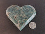 carved Blue Apatite Crystal under indoor light - size comparison to penny bottom view