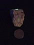 Autunite on Matrix Mini-Cabinet Specimen on display under indoor light size comparison to copper penny rear view