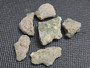 six piece Trinitite lot on display under indoor light