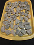 Trinitite Lot 1/4 lb 54 pieces, each smaller than 4 grams. on a yellow tray