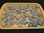 Trinitite Lot 1/4 lb 54 pieces, each smaller than 4 grams. on a yellow tray