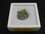 showing how this 1.5 Gram Trinitite sample with black inclusions is displayed under indoor light in a labeled case top view