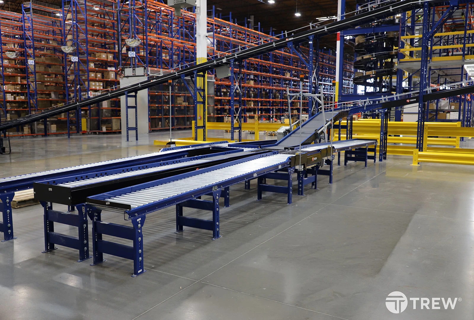 Automated conveyor in a warehouse with pallet rack system in the background