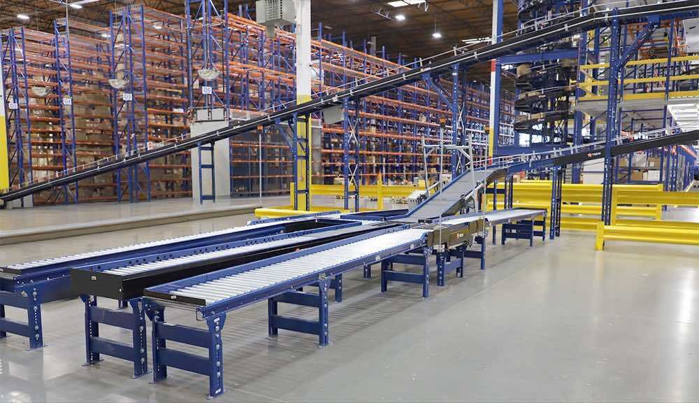 Automated conveyor in a warehouse with pallet rack system in the background
