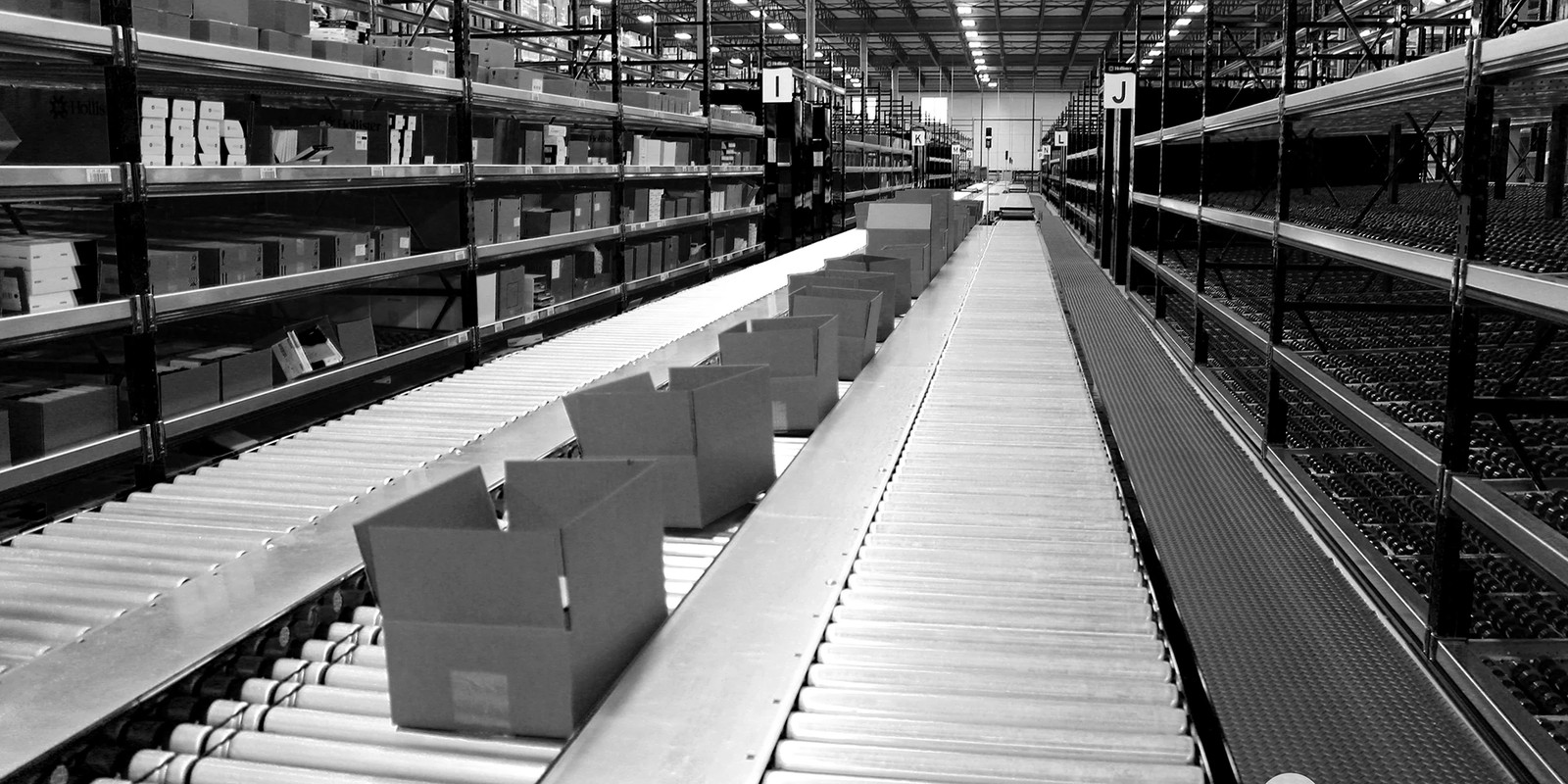 Pick module system in a warehouse with boxes on conveyor and gravity flow rack